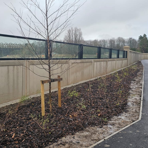 Glass flood panels a top a concrete wall by a river