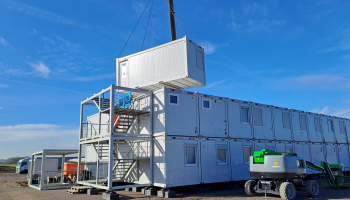 Image showing an accommodation unit being lifted into a site set up, external staircase also visible