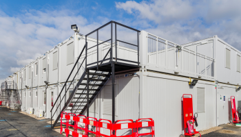 A site set up of accommodation units, with black external staircase
