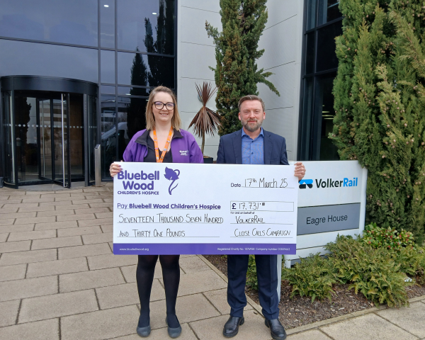 Two people holding a big cheque