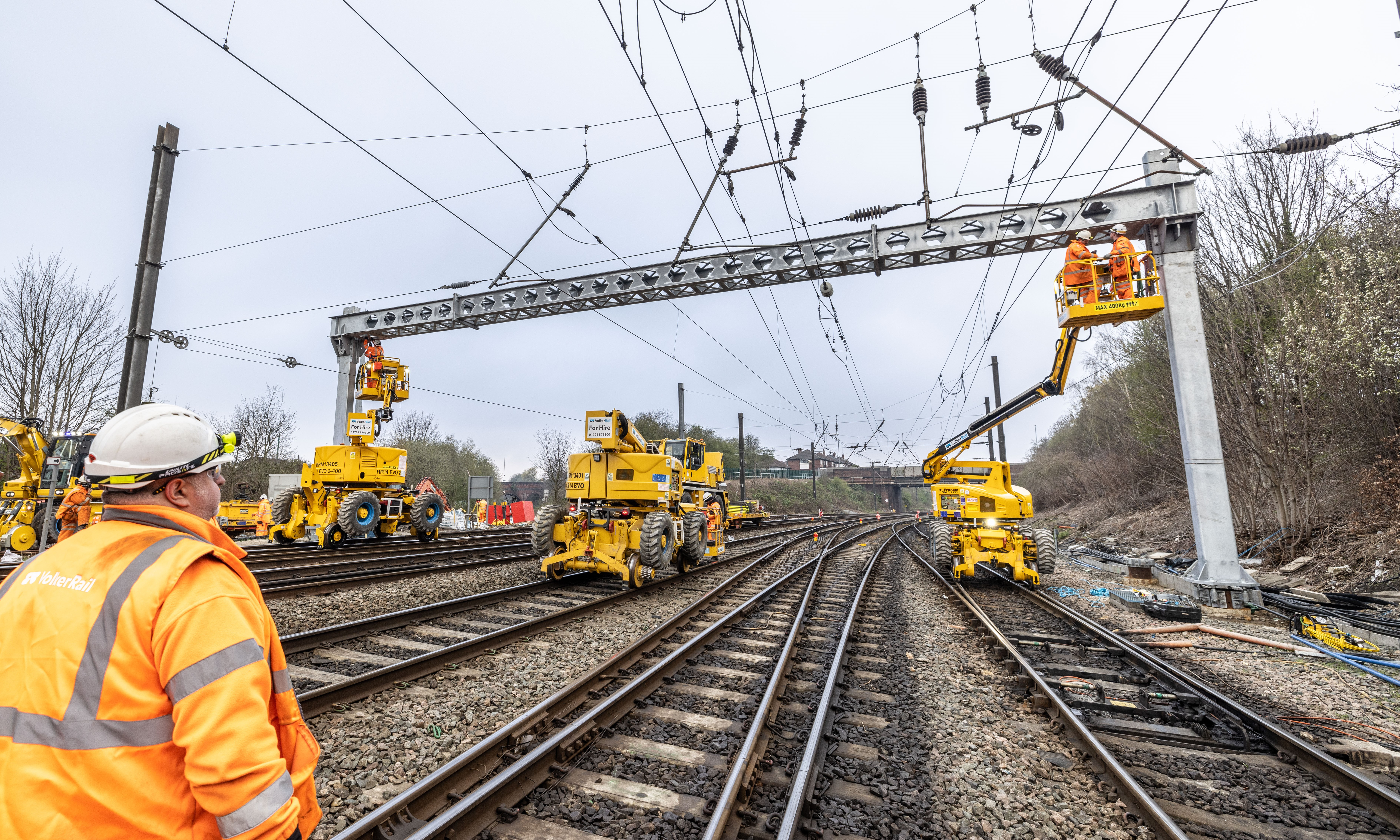 OLE gantry being installed using Mewps, with a safety supervisor watching 